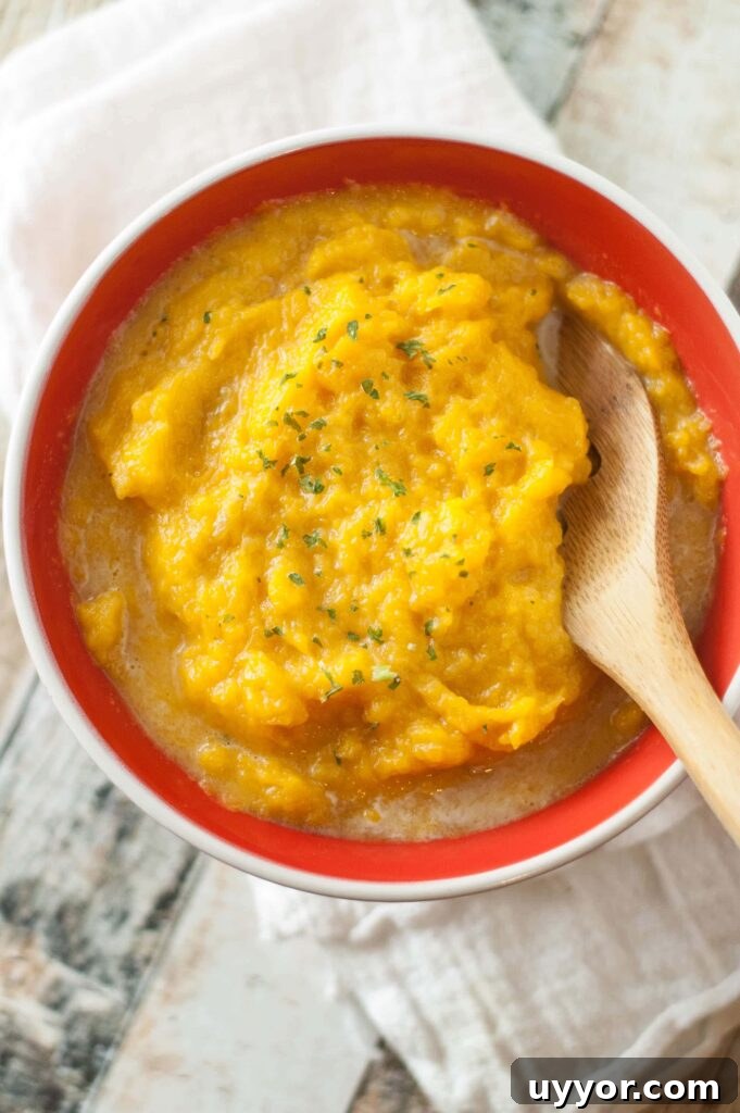 butternut squash in red bowl with wooden spoon