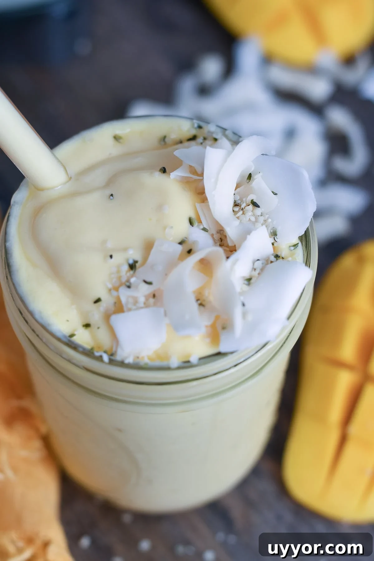 Overhead view of smoothie in a jar with a glass straw