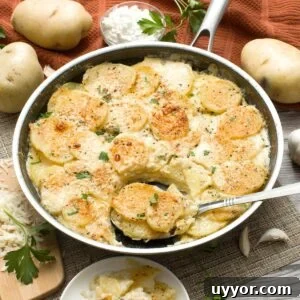 A Hexclad Hybrid skillet filled with au gratin potatoes being dished out with a large spoon.