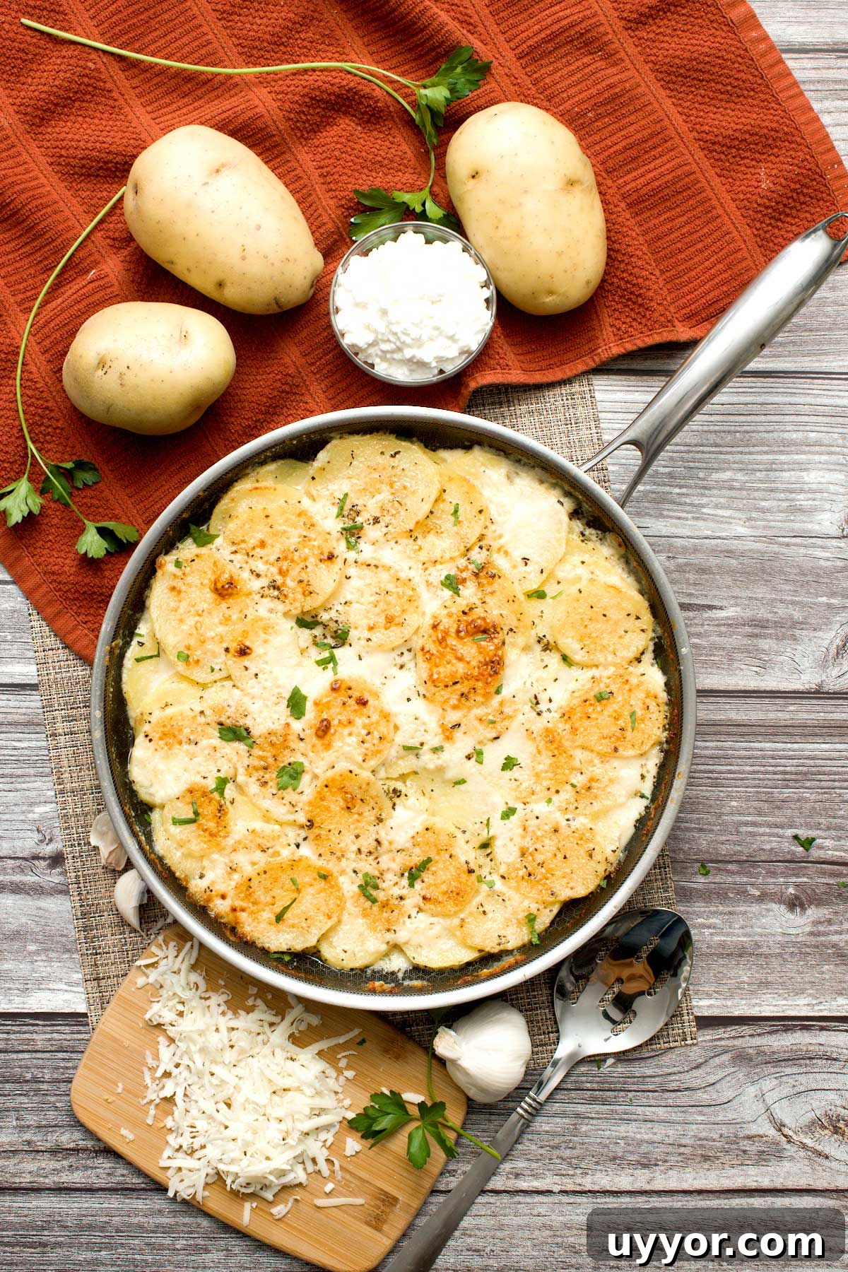 An overhead view of a Hexclad hybrid pan full of au gratin potatoes with cottage cheese.