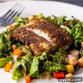 zaatar crusted cod on plate with salad