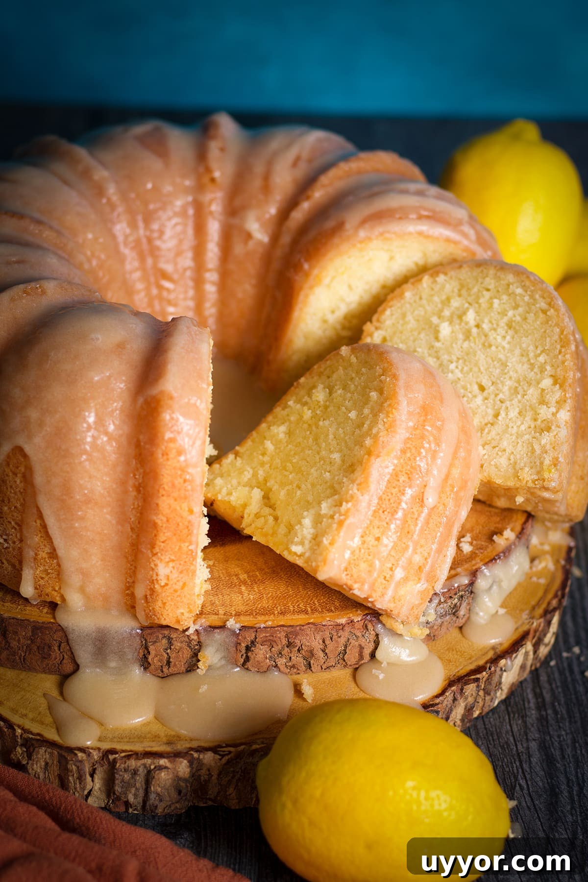 Lemon Bundt Cake with Zesty Tart Lemon Glaze 2 A partially sliced lemon bundt cake covered with lemon icing.