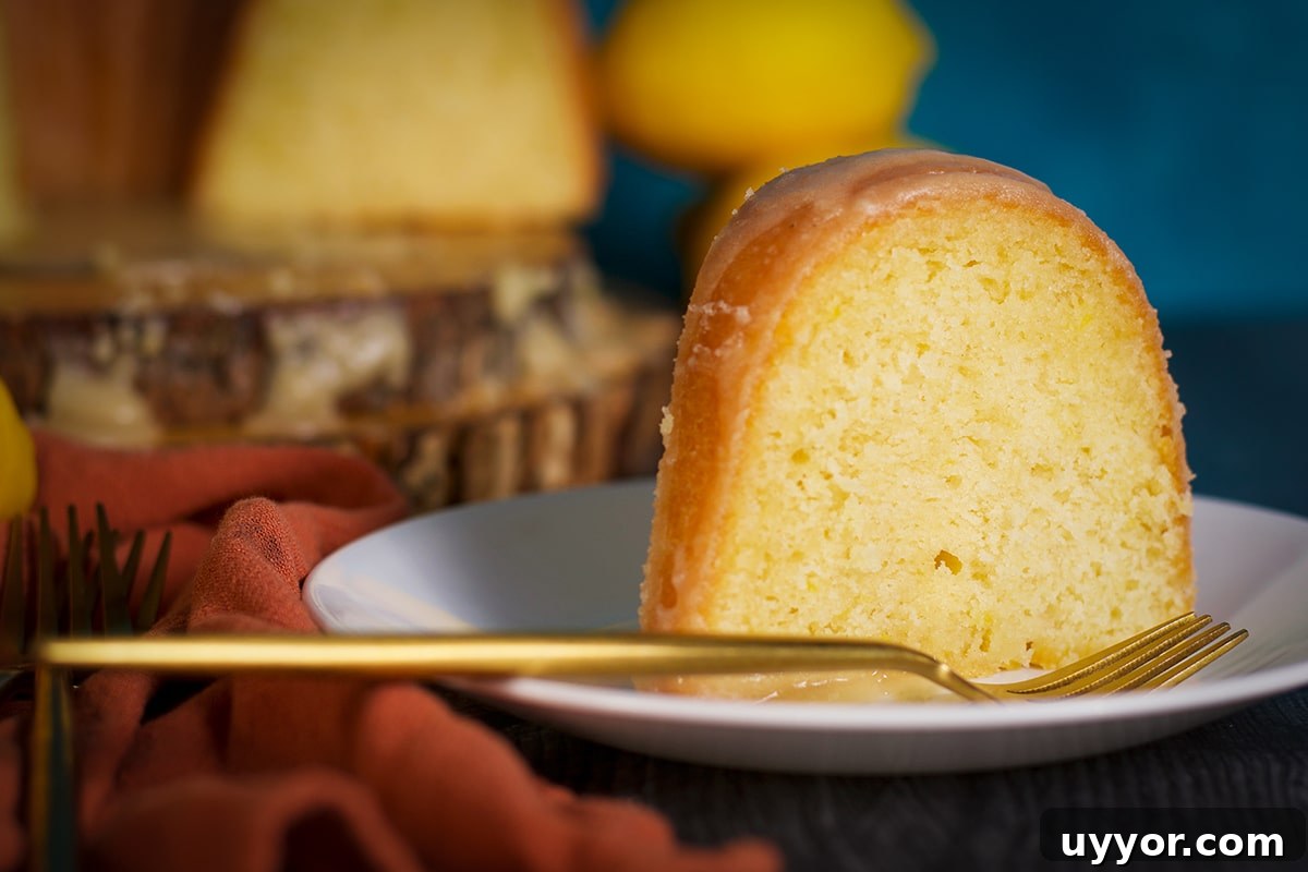 Lemon Bundt Cake with Zesty Tart Lemon Glaze 18 A slice of lemon bundt cake on a plate with a fork.