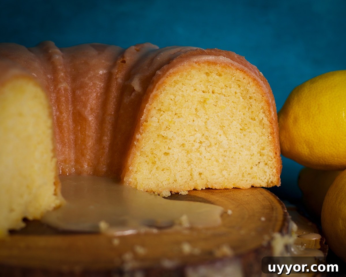 Lemon Bundt Cake with Zesty Tart Lemon Glaze 24 Half of a lemon bundt cake on a wood serving platter.