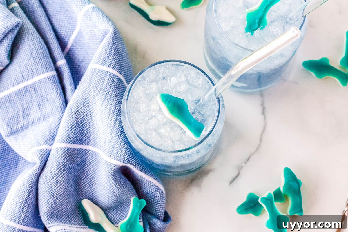 Copycat Swig Shark Attack Drink Recipe — How to Make It at Home 3 Two Swig shark attack drinks are on a counter, and gummy sharks surround them.