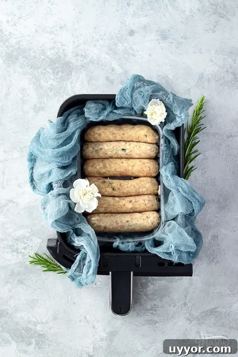 Air Fryer Cooking Times UK: Quick Guide by Food Type 10 Raw sausages in a ninja air fryer drawer with a linen napkin
