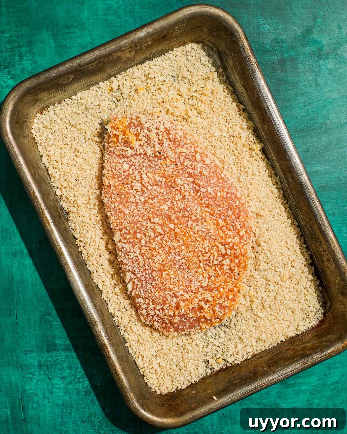 Crispy Panko Buffalo Chicken Cutlets With Tangy Sauce 4 Breaded chicken breast resting in panko crumbs before frying.