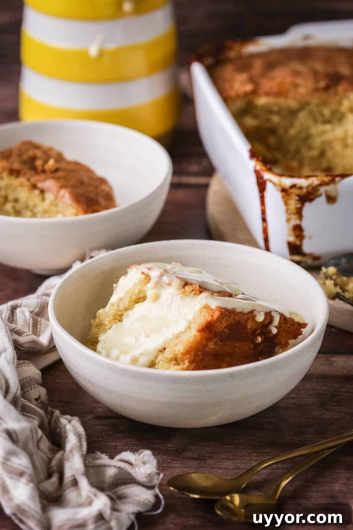 Gluten-Free Lemon Curd Sponge Pudding Recipe for Zesty Dessert 11 Portion of lemon pudding in a bowl with custard poured over top.