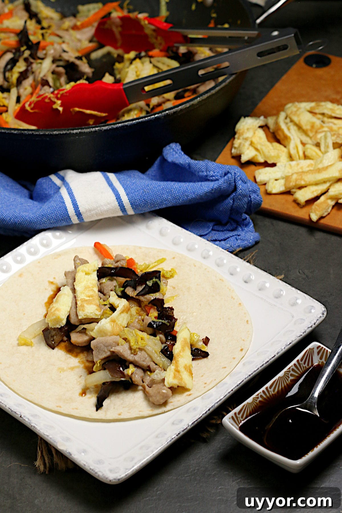 Weeknight Moo Shu Pork Recipe with Quick Hoisin Wraps 5 Easy Weeknight Moo Shu Pork in a flour tortilla on a square, white plate.