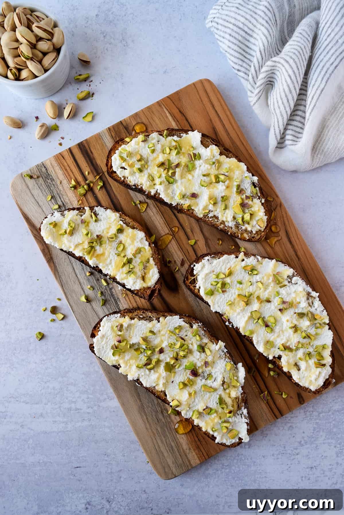 Ricotta Honey Toast with Pistachios on a cutting board.