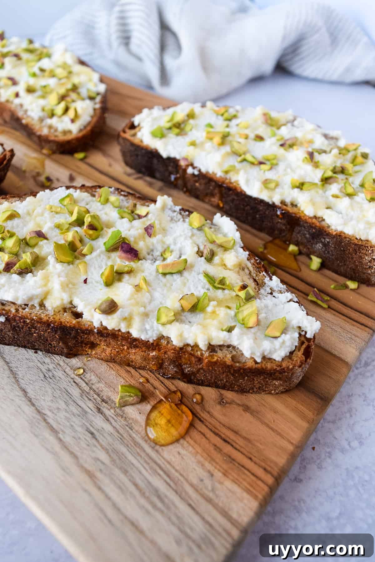 Ricotta Honey Toast with Pistachios on a cutting board.