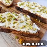 Ricotta Honey Toast with Pistachios on a cutting board.