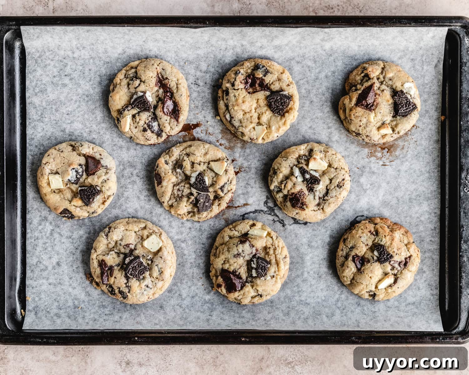 Freshly baked Oreo chocolate chip cookies on a sheet tray.