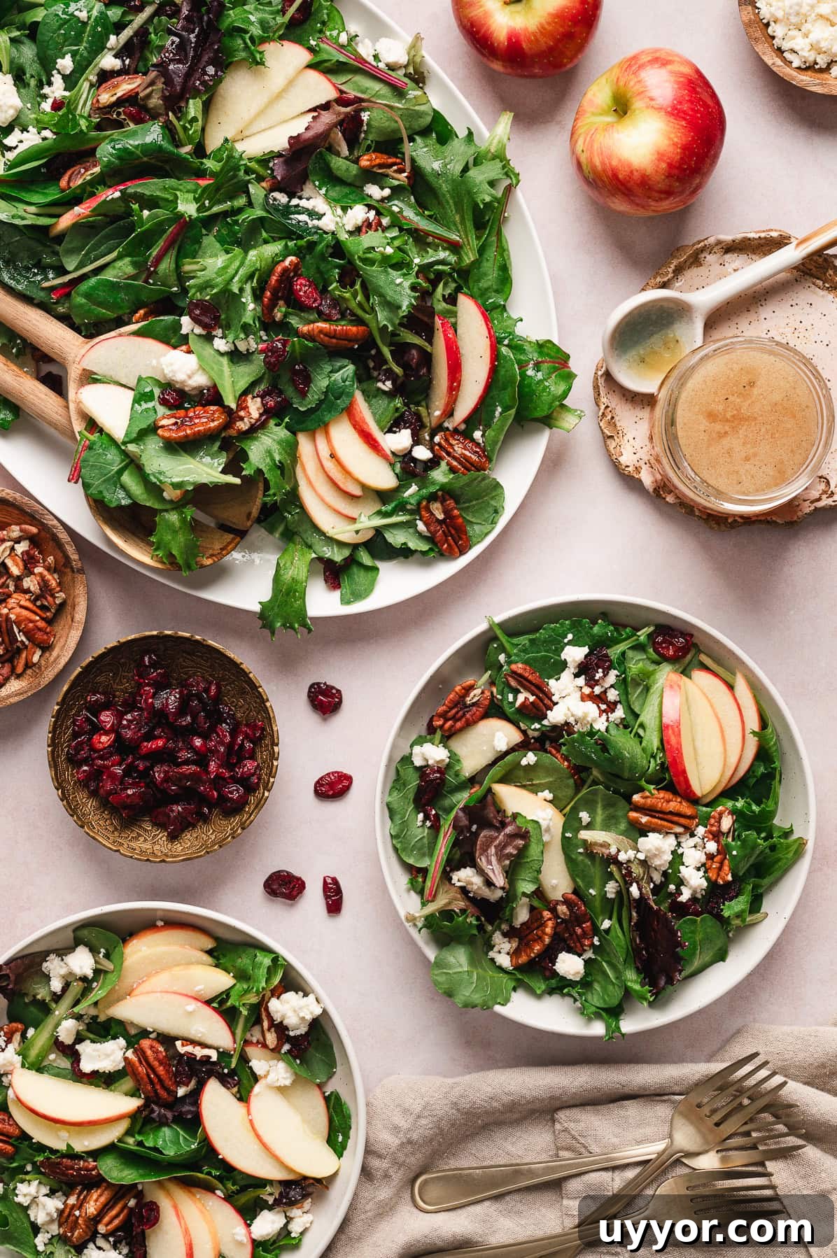 bowls of green leafy salad with apples and pecans