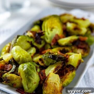 cooked brussels sprouts and bacon in white rectangular dish