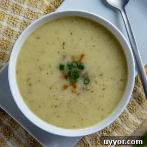 Creamy Keto Cauliflower Soup Recipe – Low-Carb Comfort Bowl 10 Soup in round white bowl sitting on white square plate. Soup topped with sliced green onions.