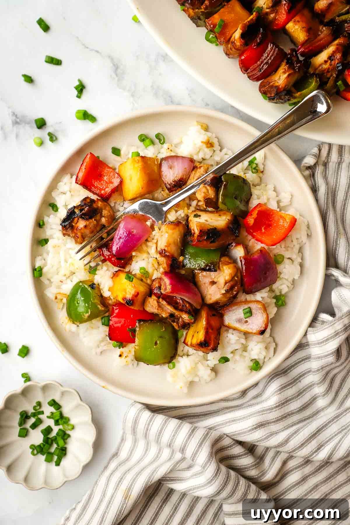 Sticky Teriyaki Chicken Skewers with Grilled Pineapple 9 a plate of teriyaki chicken and vegetables served over rice.
