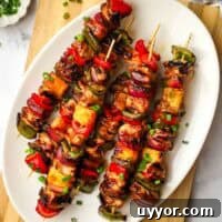 Sticky Teriyaki Chicken Skewers with Grilled Pineapple 10 A platter of teriyaki chicken and vegetable skewers.