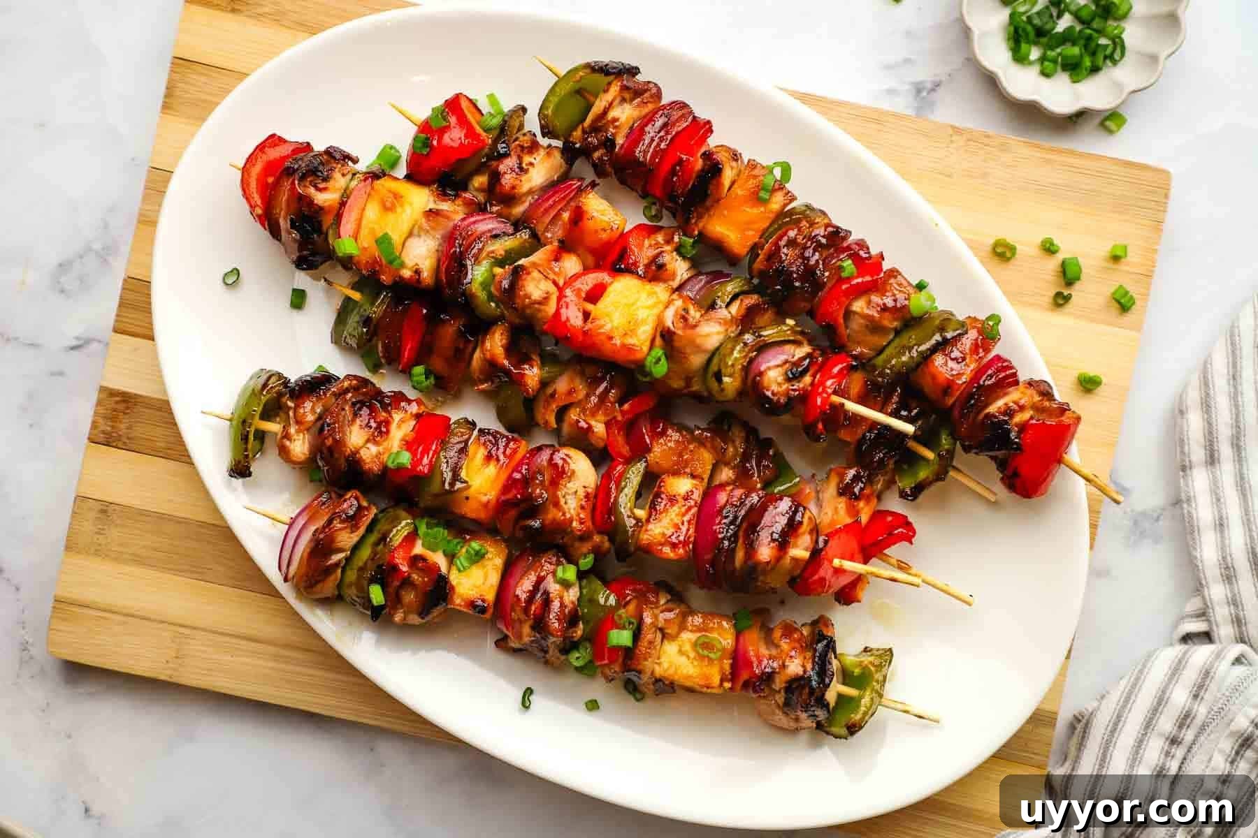 Sticky Teriyaki Chicken Skewers with Grilled Pineapple 3 a platter of teriyaki chicken and vegetable skewers.