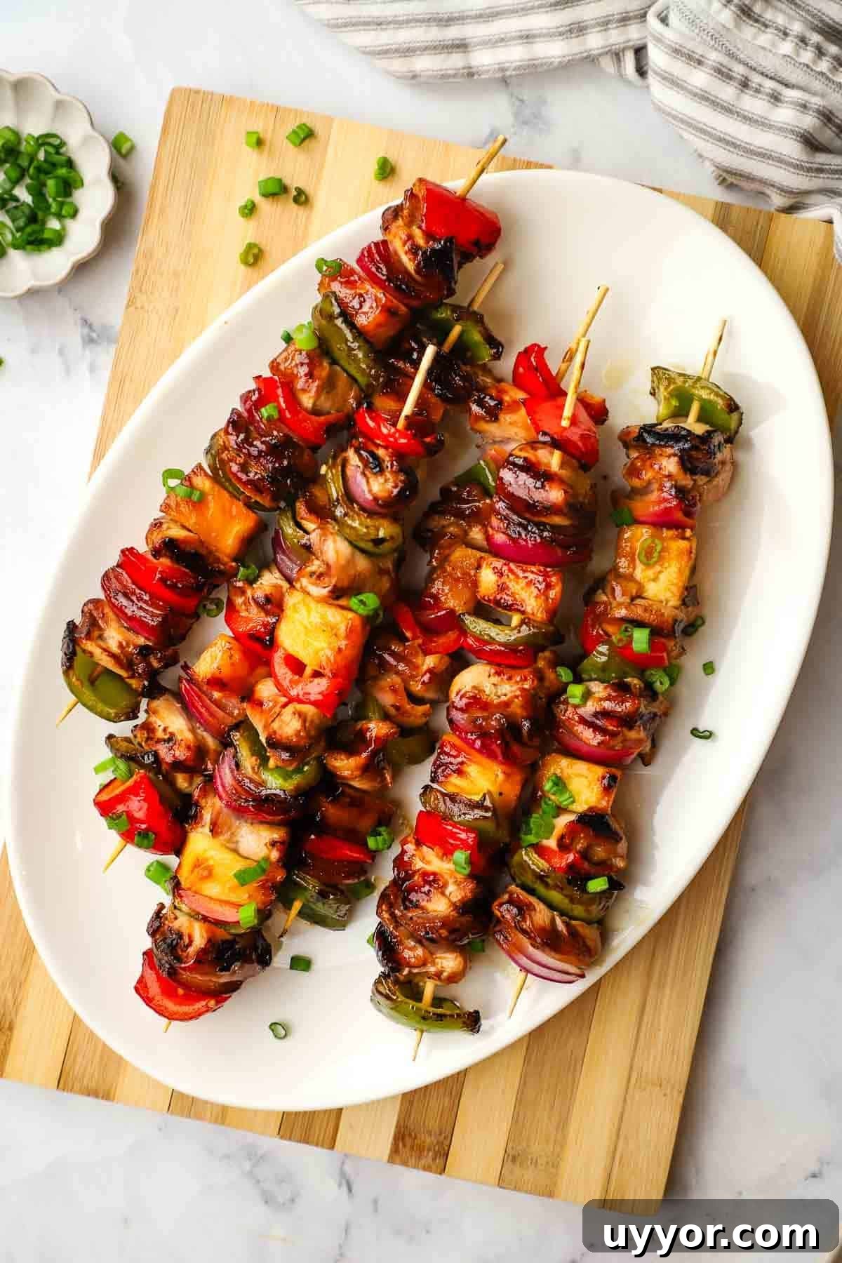 Sticky Teriyaki Chicken Skewers with Grilled Pineapple 4 A platter of teriyaki chicken and vegetable skewers.