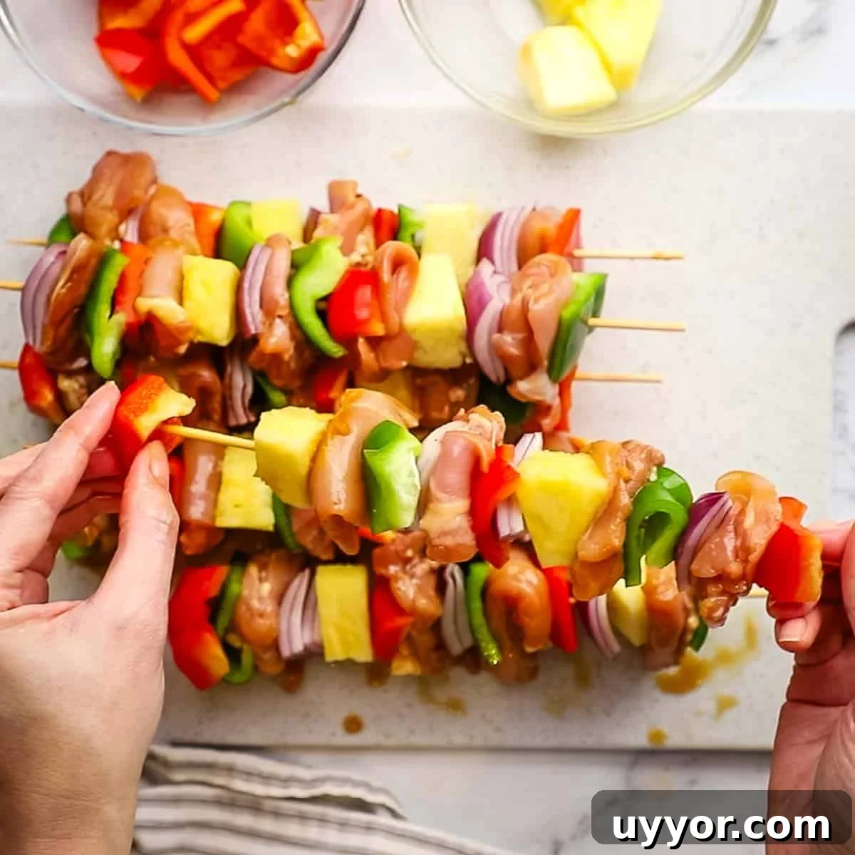Sticky Teriyaki Chicken Skewers with Grilled Pineapple 7 threading chicken and vegetables on skewers