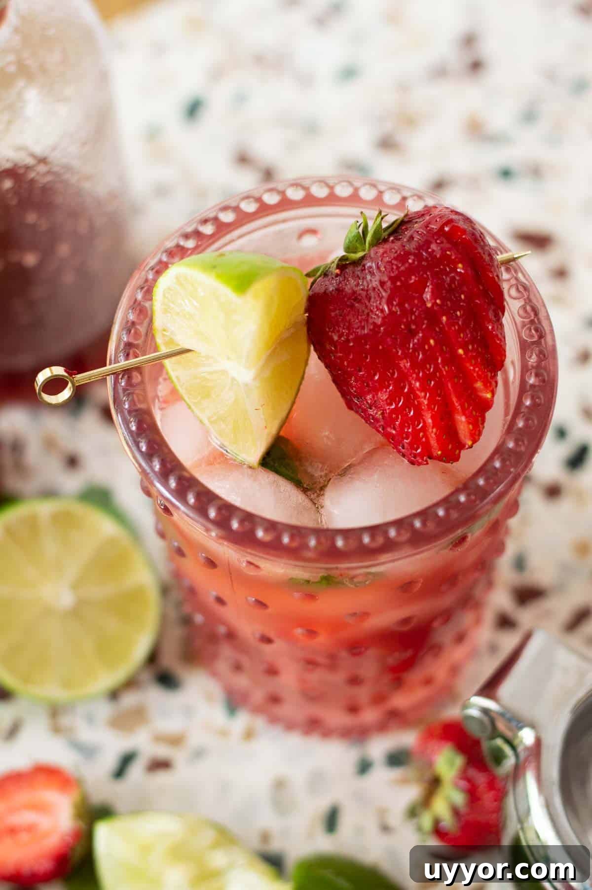 Strawberry Mojito Mocktail Recipe: Refreshing Non-Alcoholic Cocktail 3 Strawberry Mojito Mocktail with lime and strawberries on a gold pick