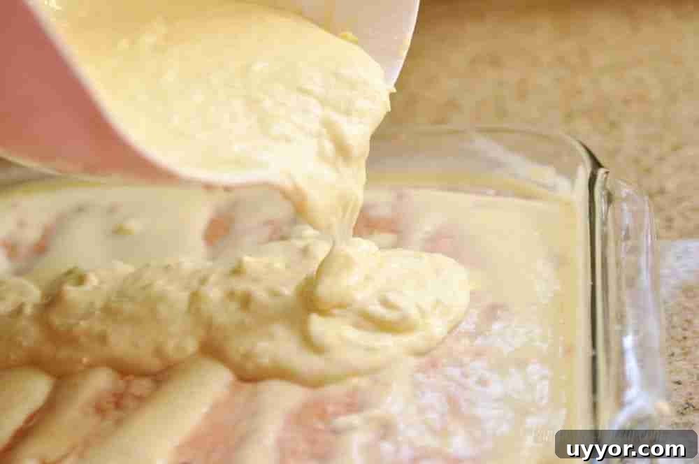 Strawberry Banana Pudding Cake Recipe — Moist Layer Cake 10 pouring pudding mix over a strawberry cake with holes.