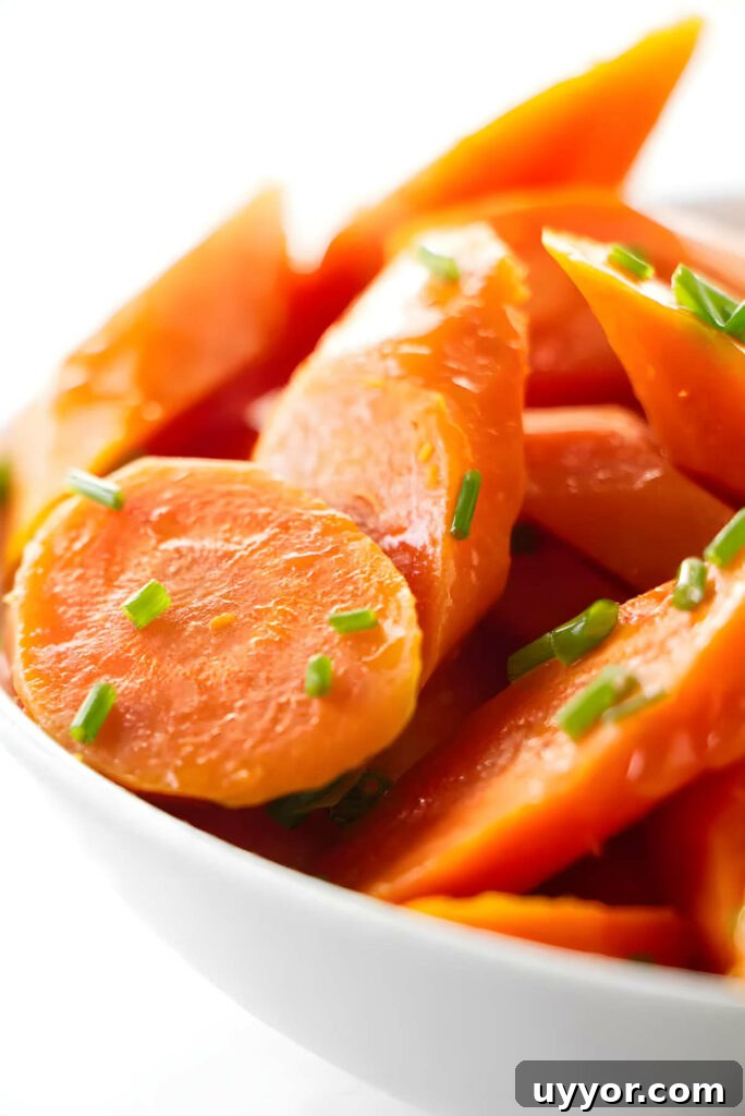 A bowl of steamed carrots topped with herbs.
