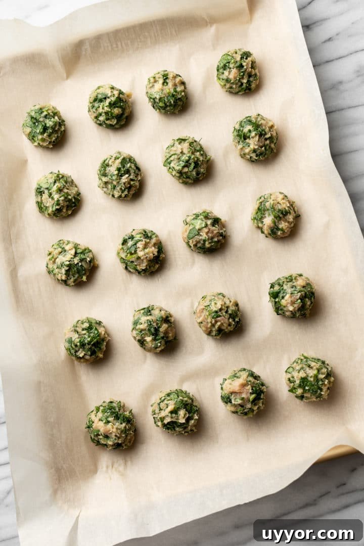 chicken and spinach meatballs on a baking sheet
