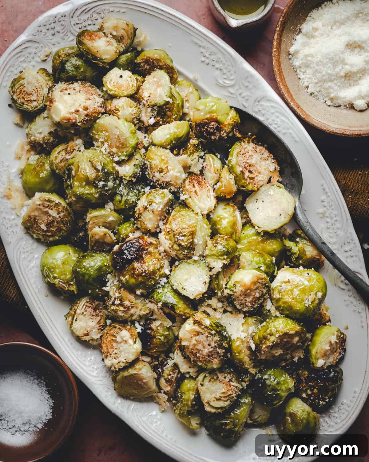 Closer shot of Garlic Parmesan Brussels Sprouts served on a white oval platter and photographed from the top.