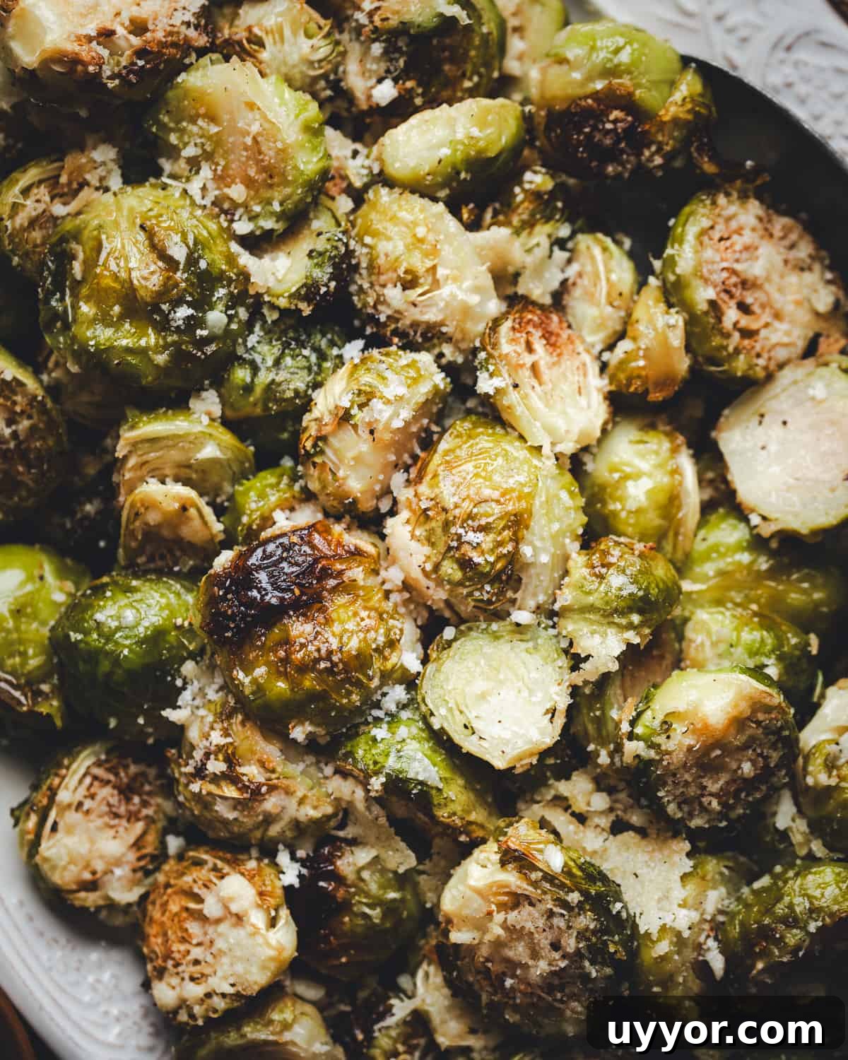 Close up Garlic Parmesan Brussels Sprouts served on a white oval platter and photographed from the top.