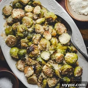 Close up shot of Garlic Parmesan Brussels Sprouts served on a white oval platter and photographed from the top.
