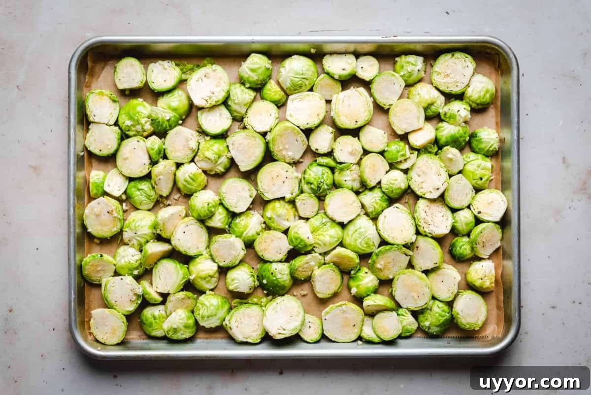 seasoned halved brussels sprouts on baking sheet before baking.