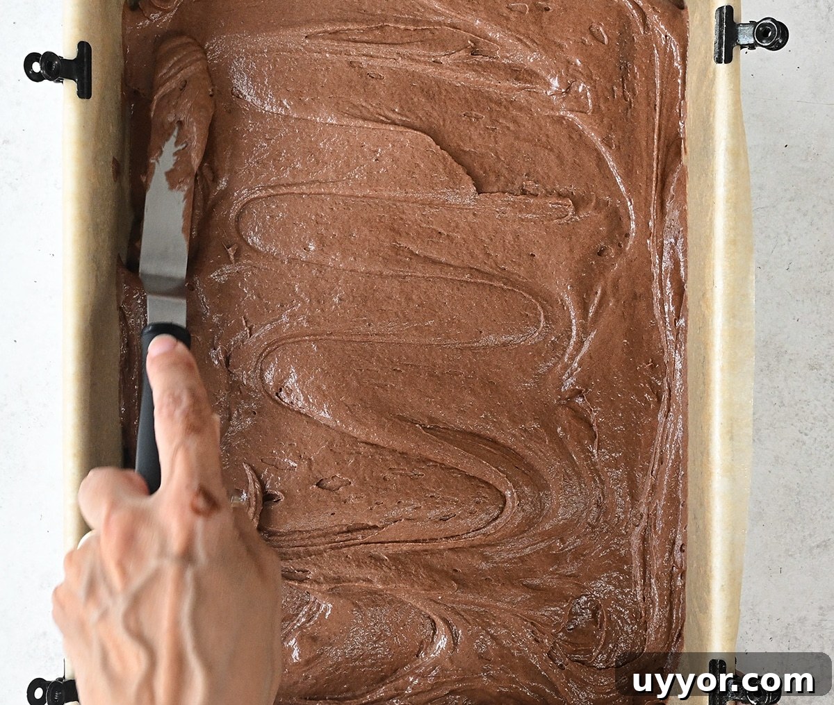 spreading cake batter in a rectangular sheet cake pan