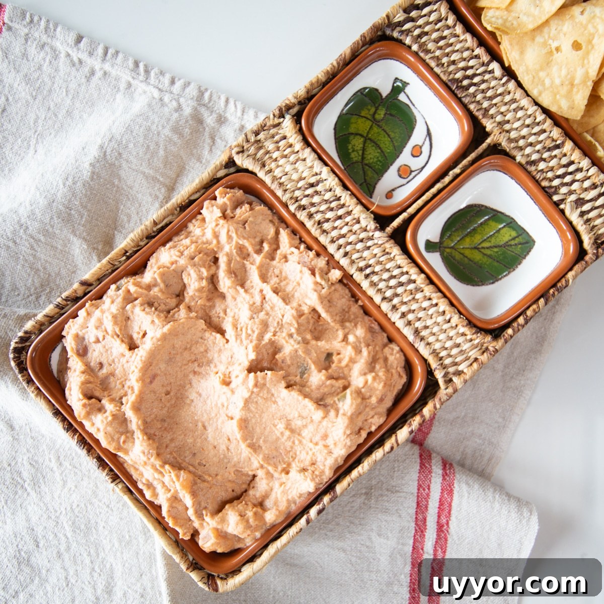 Creamy Refried Bean Dip with Canned Beans — Crowd-Pleasing Recipe 2 Refried bean dip in an appetizer tray with chips.