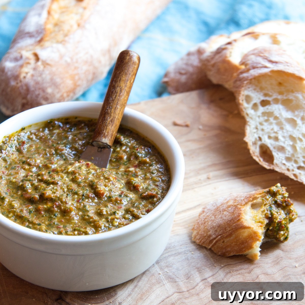 Creamy Refried Bean Dip with Canned Beans — Crowd-Pleasing Recipe 3 Ramekin of bread dipping oil on a cutting board with slices of French bread.