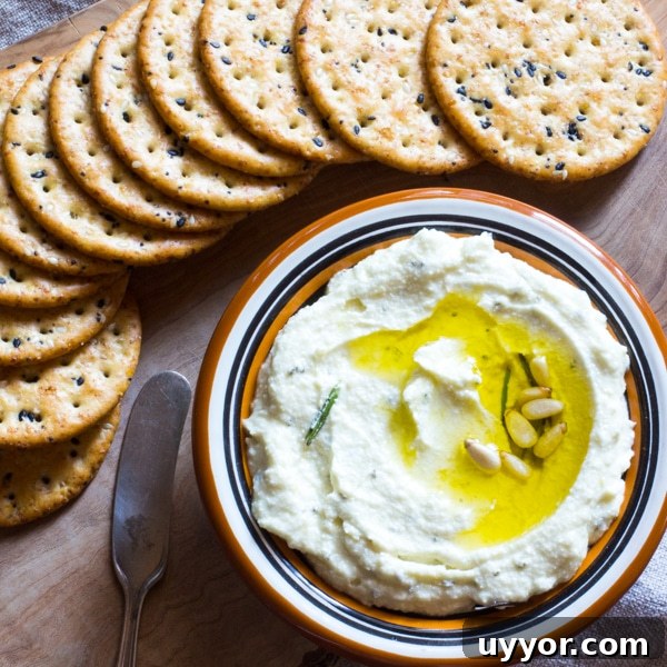 Creamy Refried Bean Dip with Canned Beans — Crowd-Pleasing Recipe 5 A small bowl of feta dip with rosemary, topped with a drizzle of olive oil.