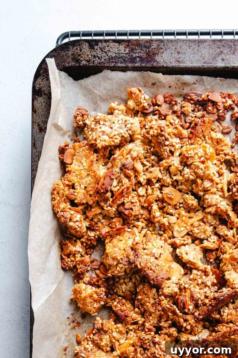 Tahini Sesame Granola with Honey & Orange 7 Wholesome granola baked on parchment paper.