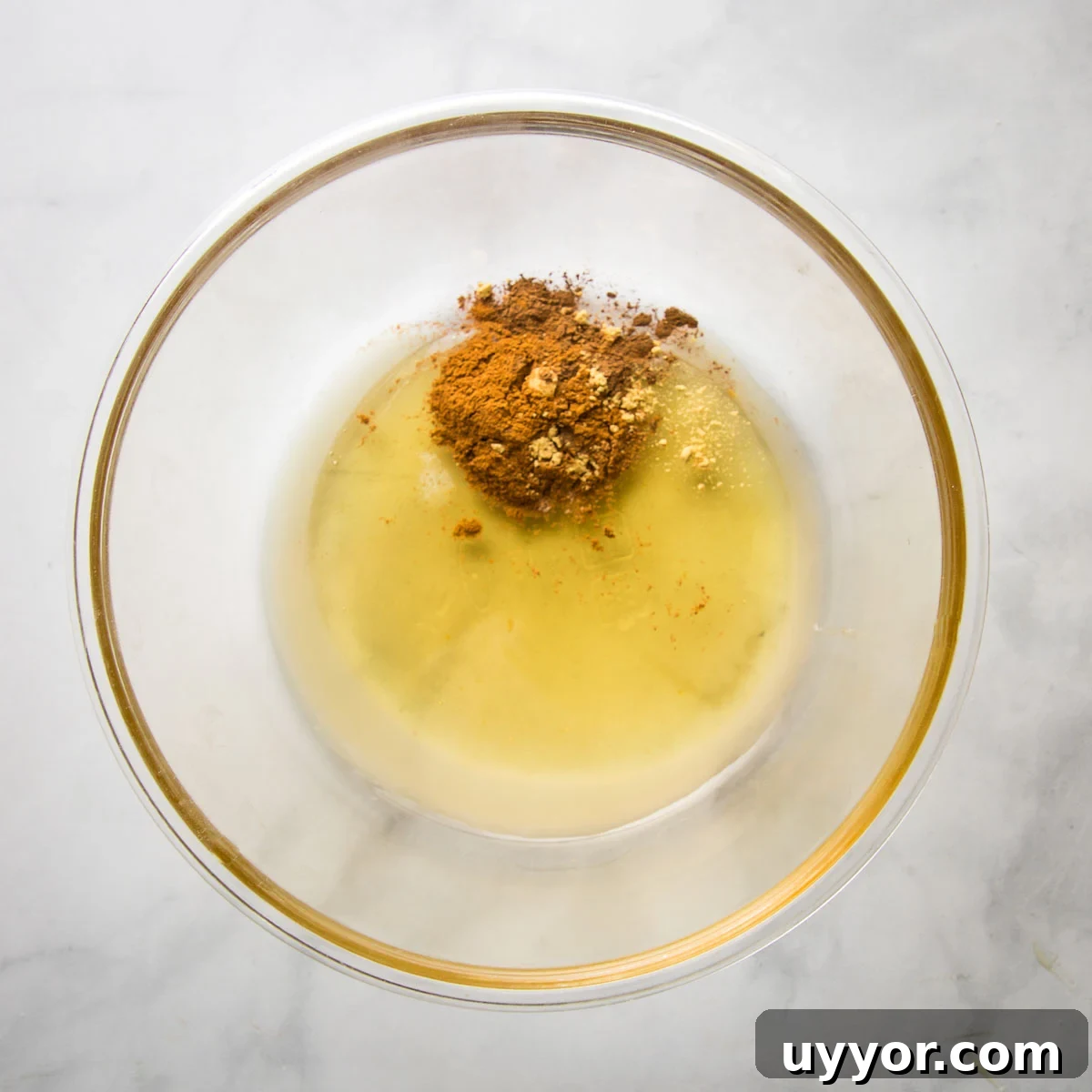 Spices, lemon juice and honey in a large glass bowl.