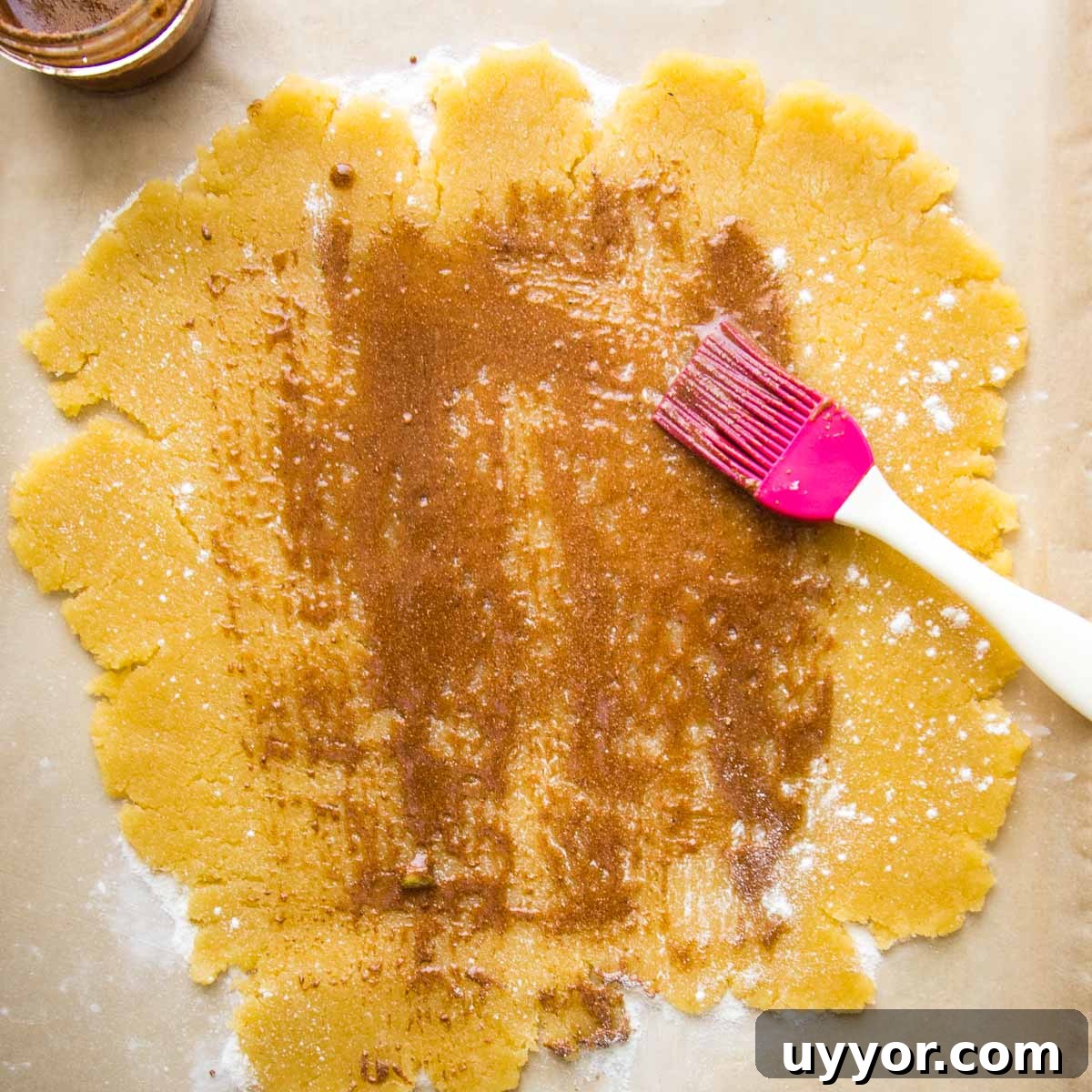Galette dough rolled into a flat circle, sprinkled with arrowroot and then brushed with spice mixture.