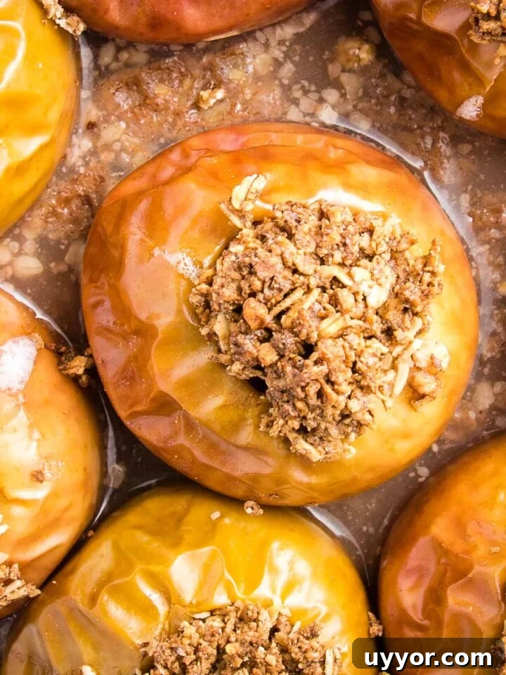 Close up of baked apples, stuffed with oatmeal in a glass pie plate.