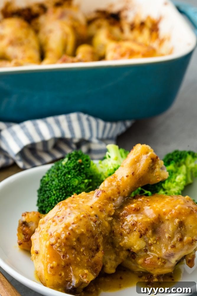 Crispy Honey Mustard Baked Chicken Drumsticks Recipe 2 chicken drumsticks with yellow sauce on them