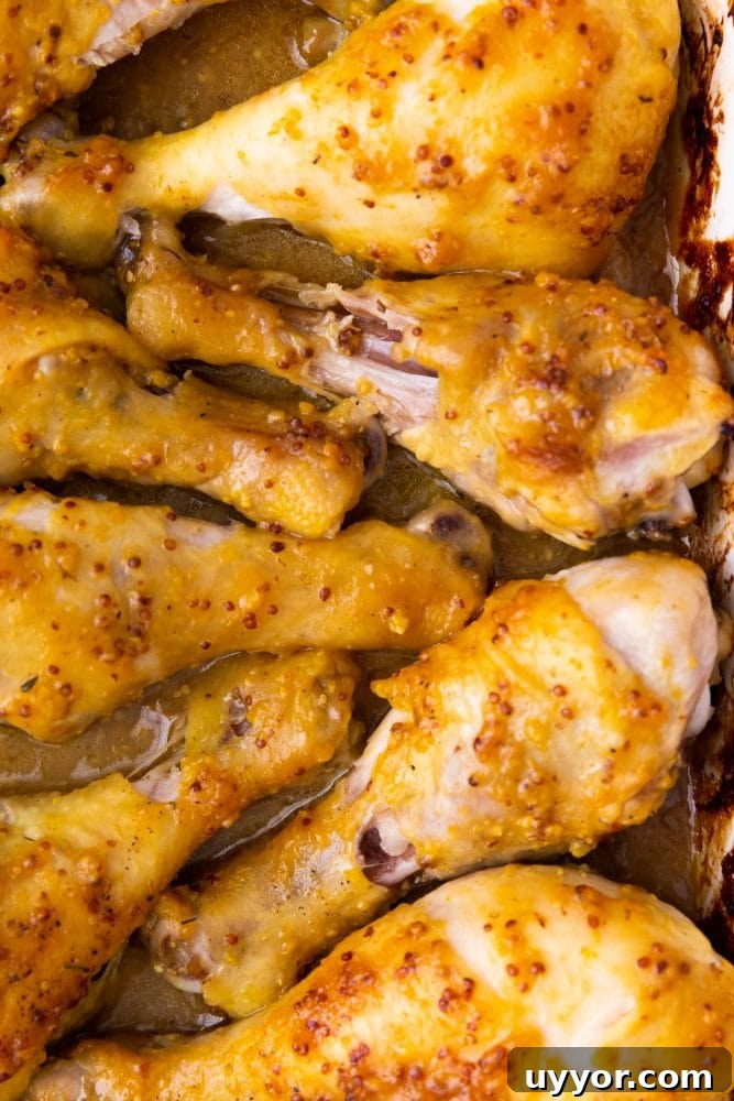 Crispy Honey Mustard Baked Chicken Drumsticks Recipe 4 chicken drumsticks with yellow sauce on them