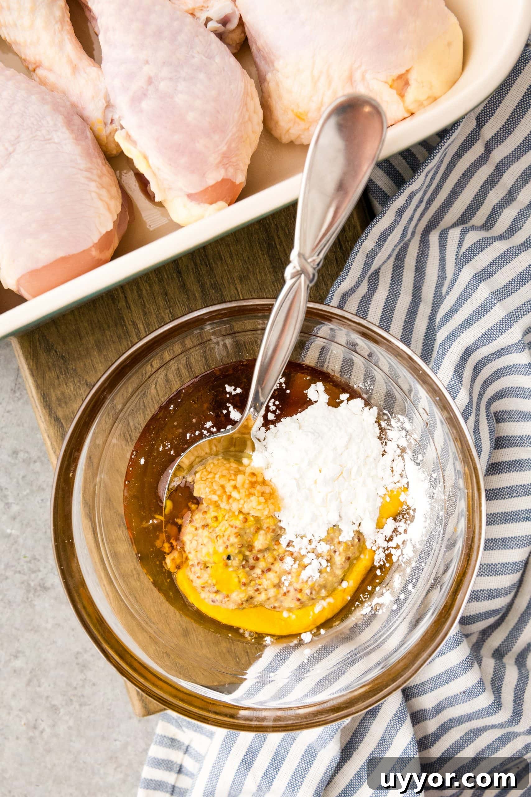 Crispy Honey Mustard Baked Chicken Drumsticks Recipe 6 A bowl of chicken drumsticks served with a spoon.