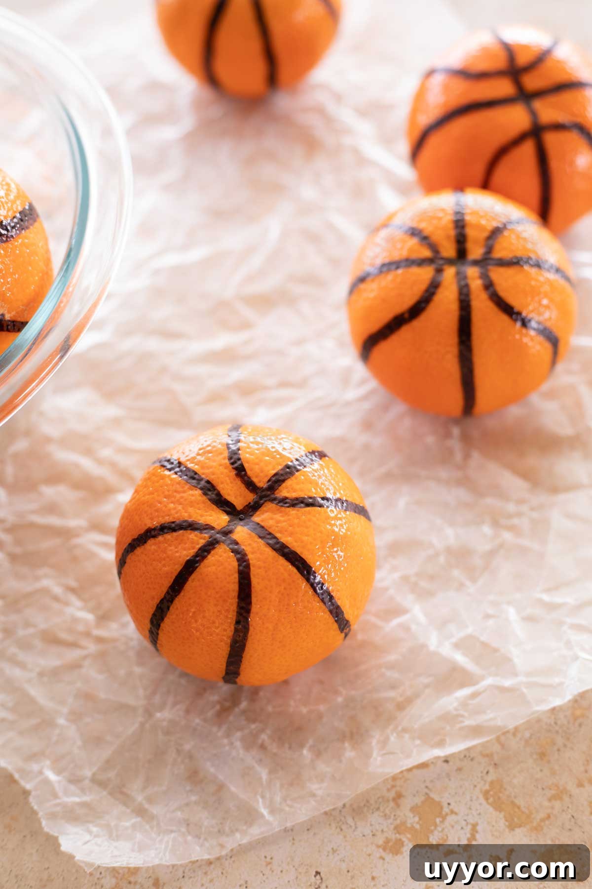 50+ Winning March Madness Game Day Recipes and Snacks 13 Closeup of a clementine that's been made into a basketball with others in background.