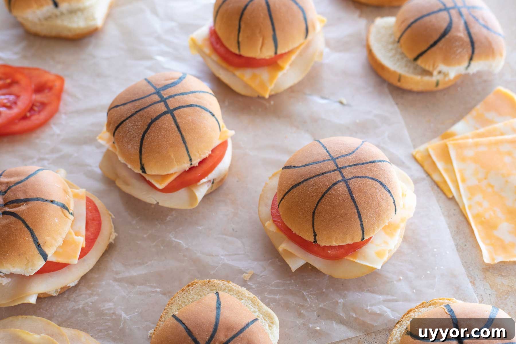 50+ Winning March Madness Game Day Recipes and Snacks 5 Finished sliders with meat, cheese and tomatoes, laying on wax paper and ready for party.