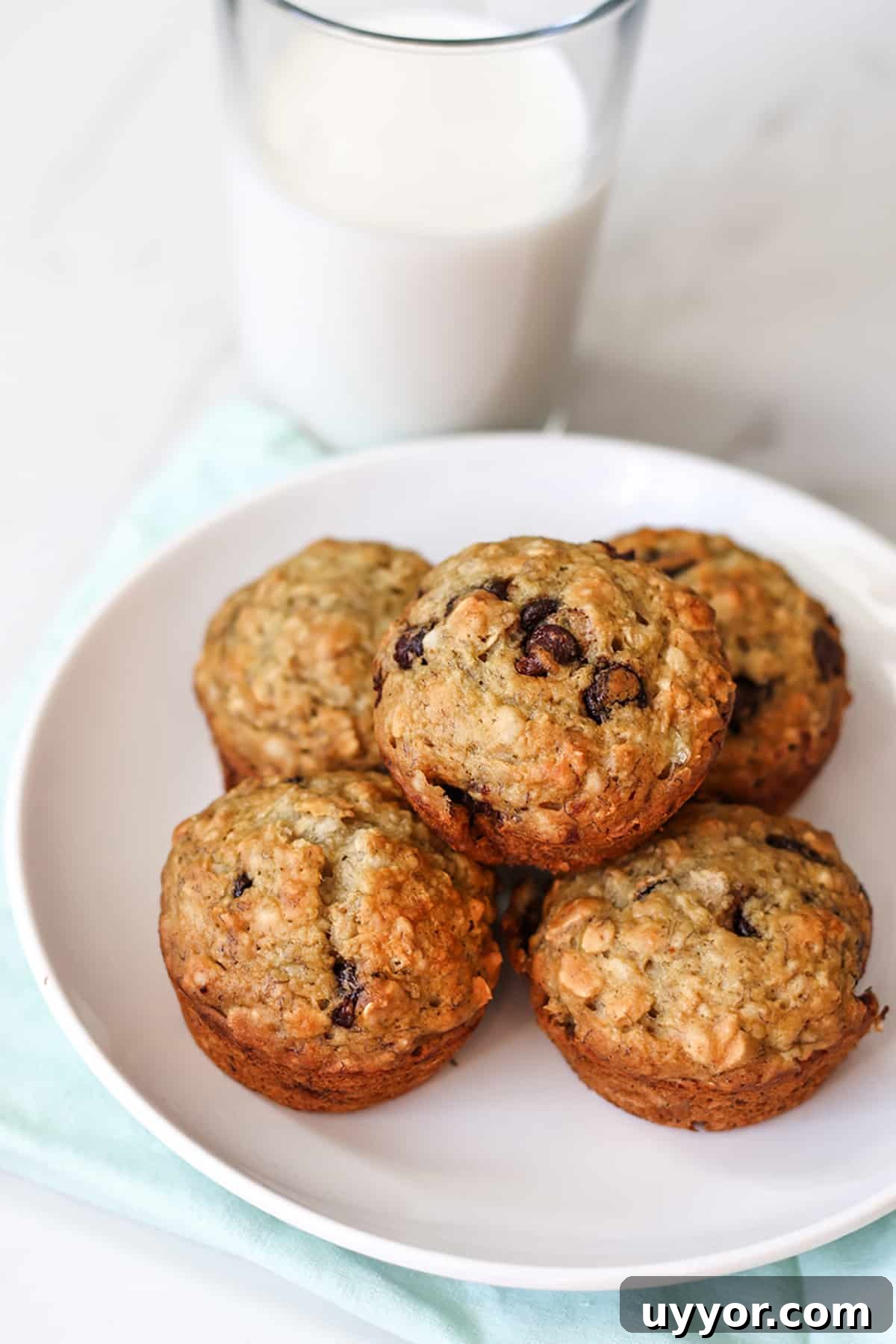 Sourdough Banana Oat Muffins with Maple Glaze 3 A plate with banana oat muffins and a glass of milk.