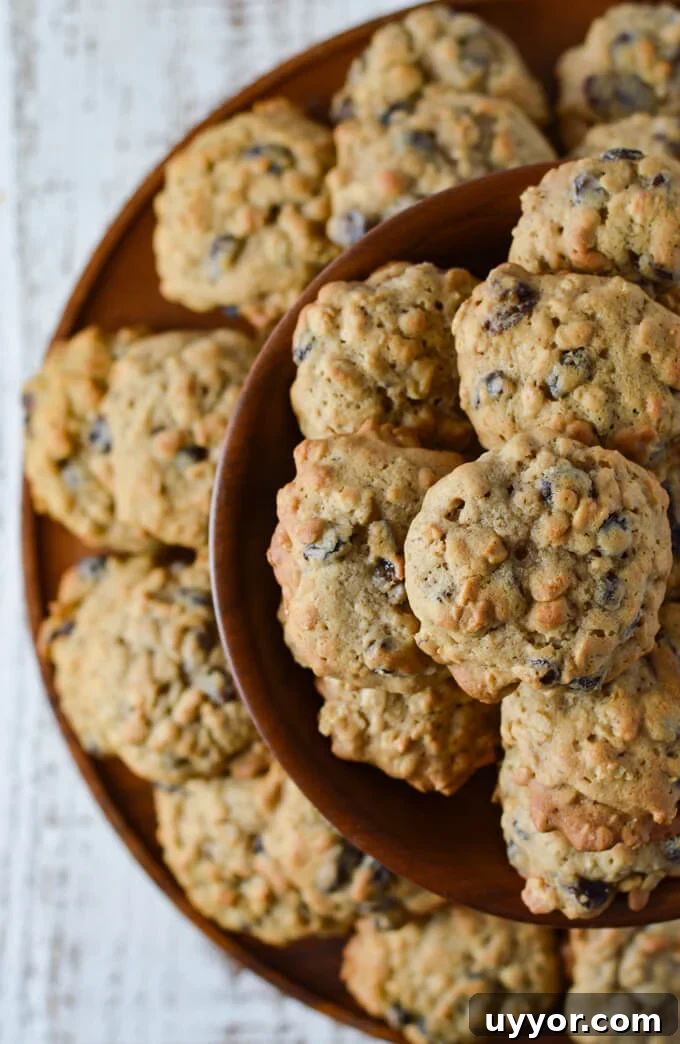 A top view of oatmeal raisin cookies on a wooden layered cookie tray.