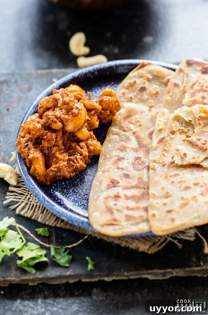 cashew curry served with parathas on a plate