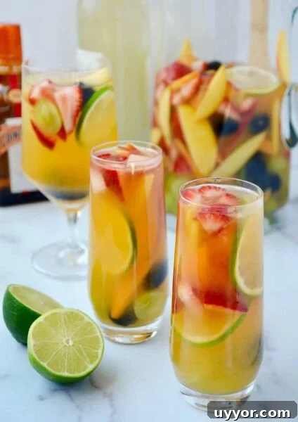 Various glasses filled with homemade white sangria with fruit.